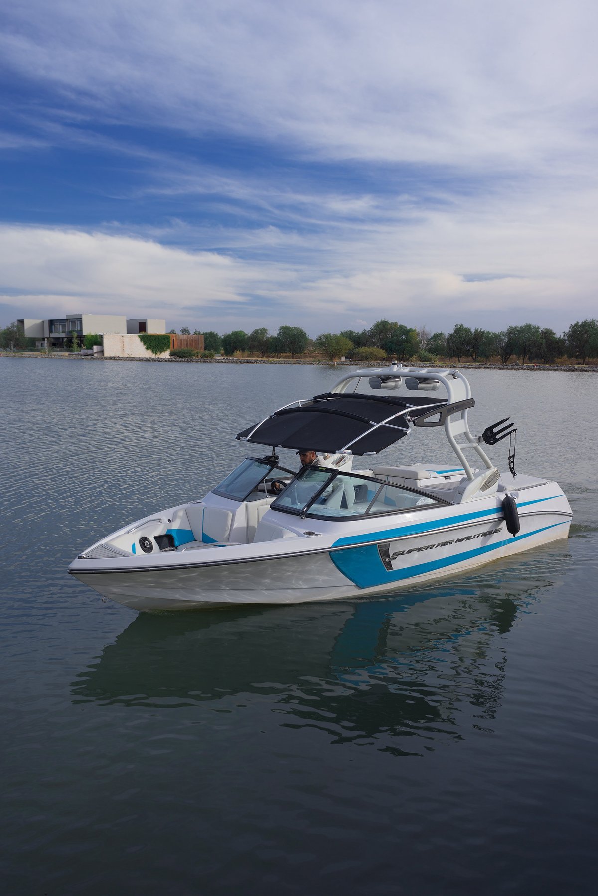 White sports boat cruising across a bright blue lake under an Arizona sky
