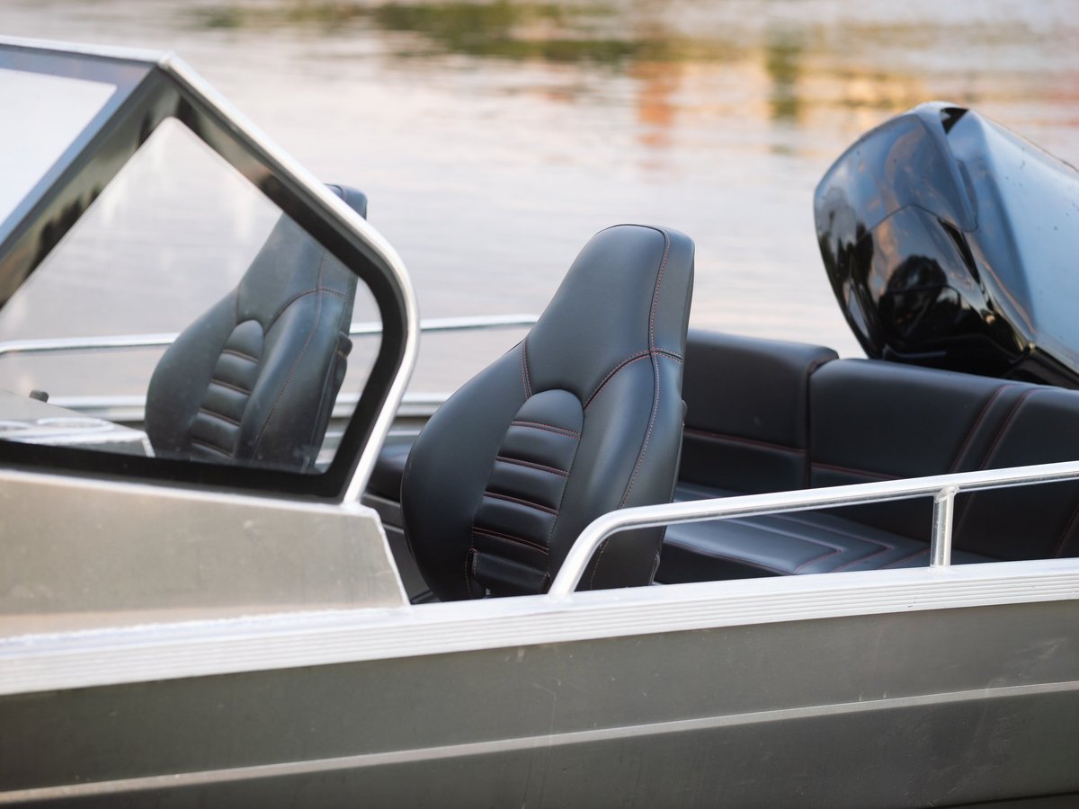 Sport boat with leather interior and outboard engine moored on a lake
