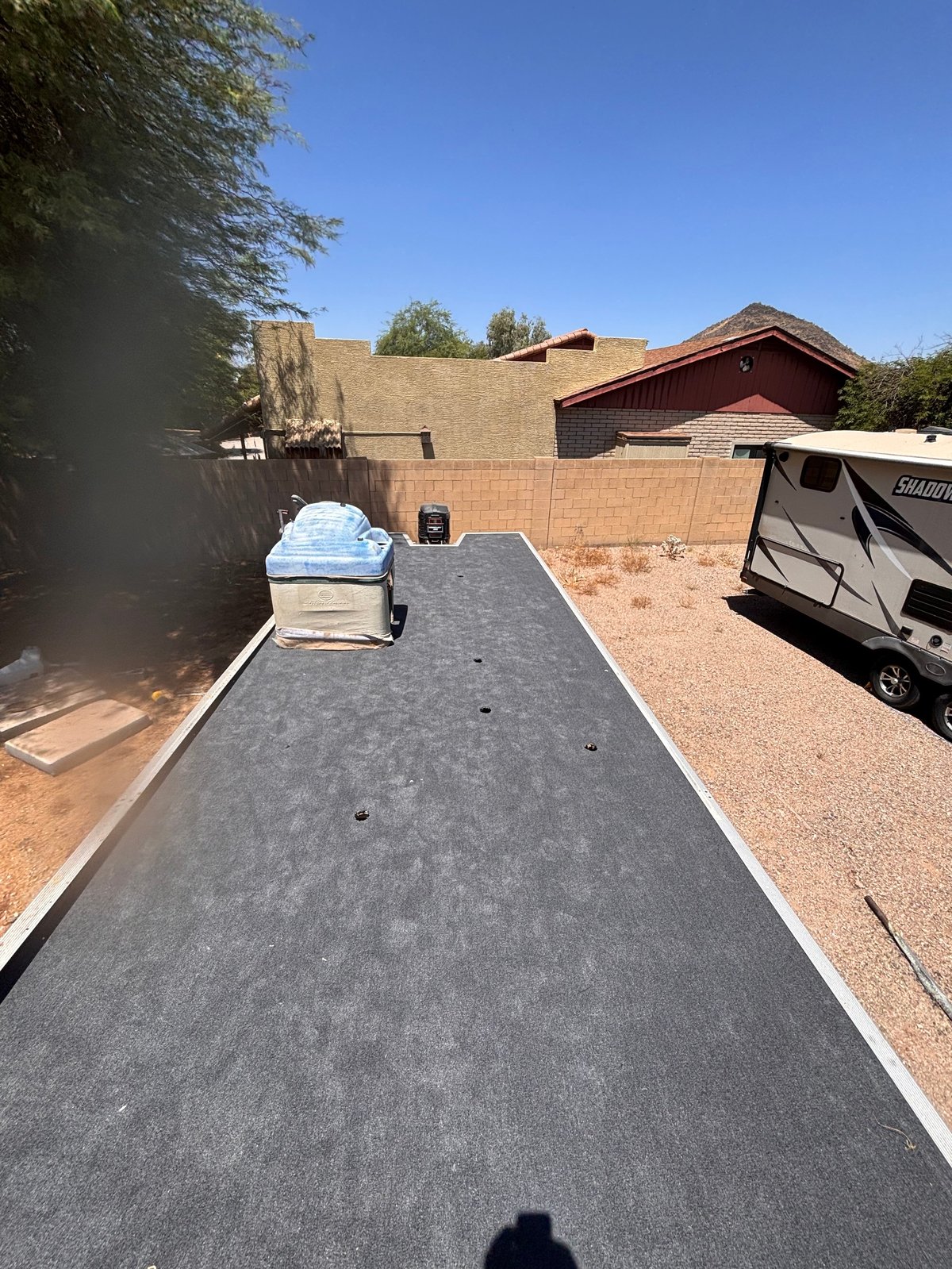 After: Pontoon deck freshly re-carpeted with marine-grade carpet, laid out on the trailer in a residential yard