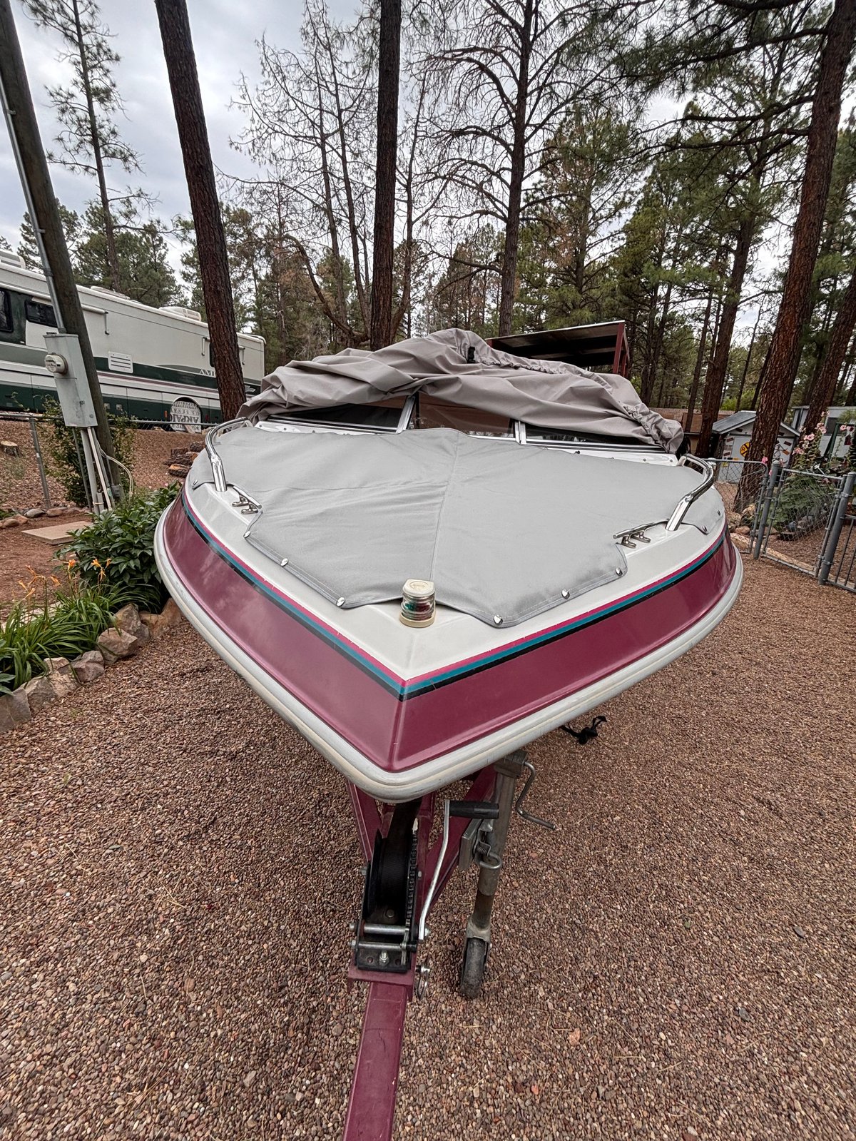 White and burgundy speedboat with custom snap-on bow cover, viewed from the bow