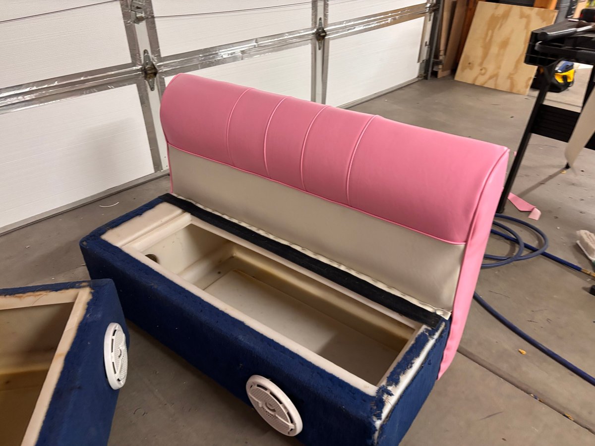 After: Pontoon party barge bench seat reupholstered in pink and navy customer-supplied vinyl, with cream side panel and open storage compartment